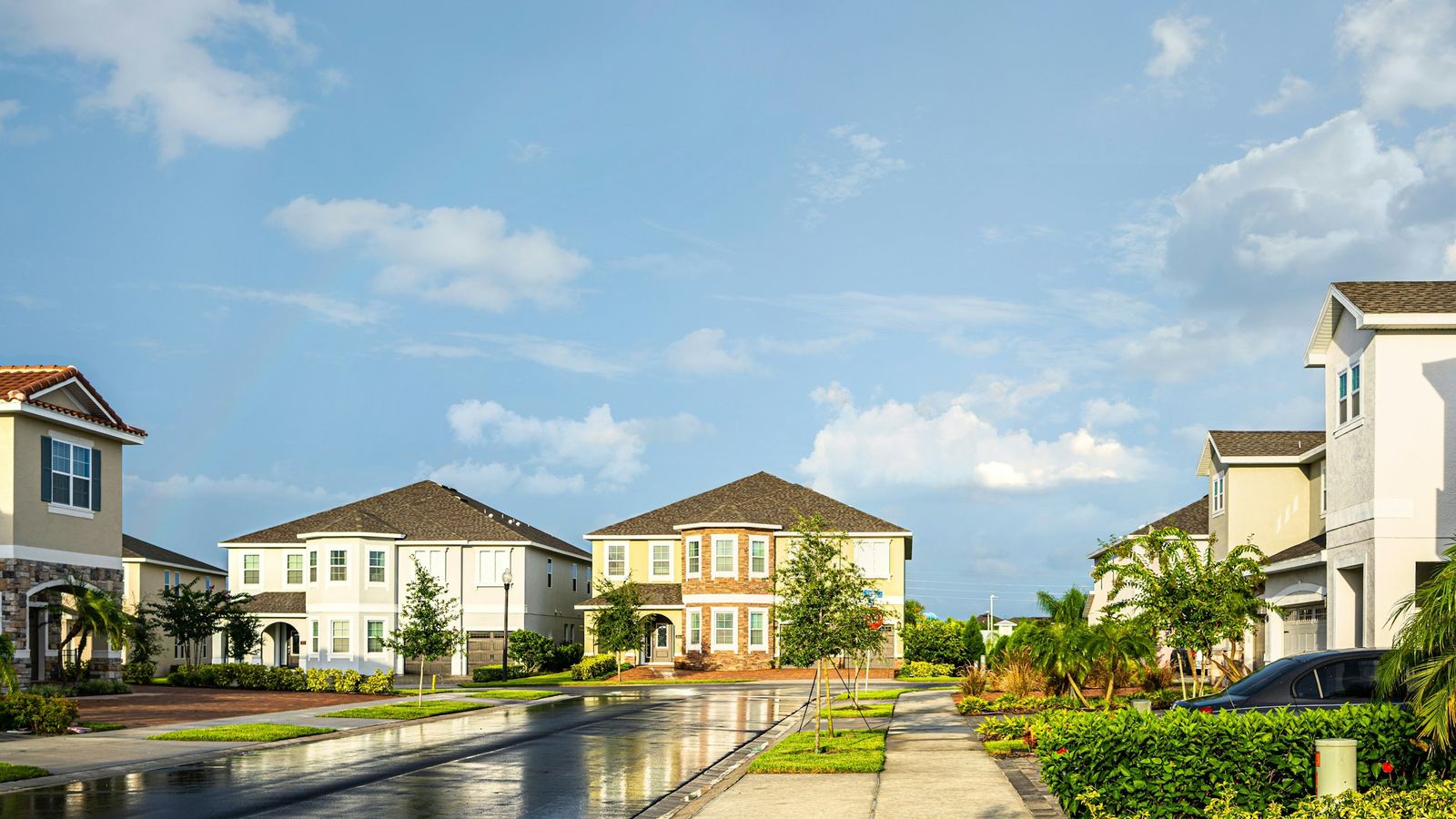 Two-story homes and palms lining a quiet Orlando neighborhood street