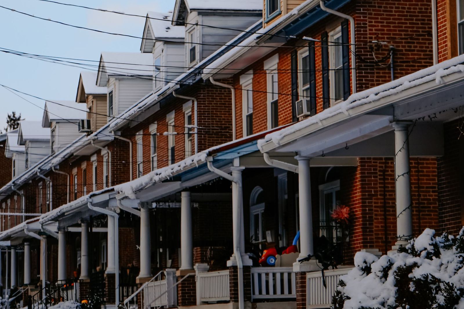 Row of brick porch-front rowhomes dusted with fresh snow